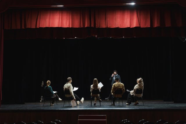 People on a stage practicing for a play